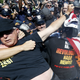 A law enforcement officer takes Gregory “Joey” Johnson into custody after he started to burn an American flag in Cleveland, during the third day of the Republican convention, July 2016. Photo via AP